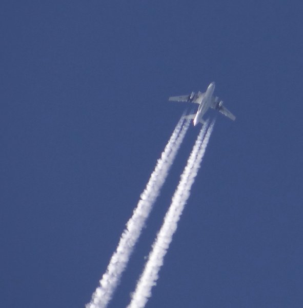 With its typical contrails, an Il-76 caught in a blue hole between the clouds.