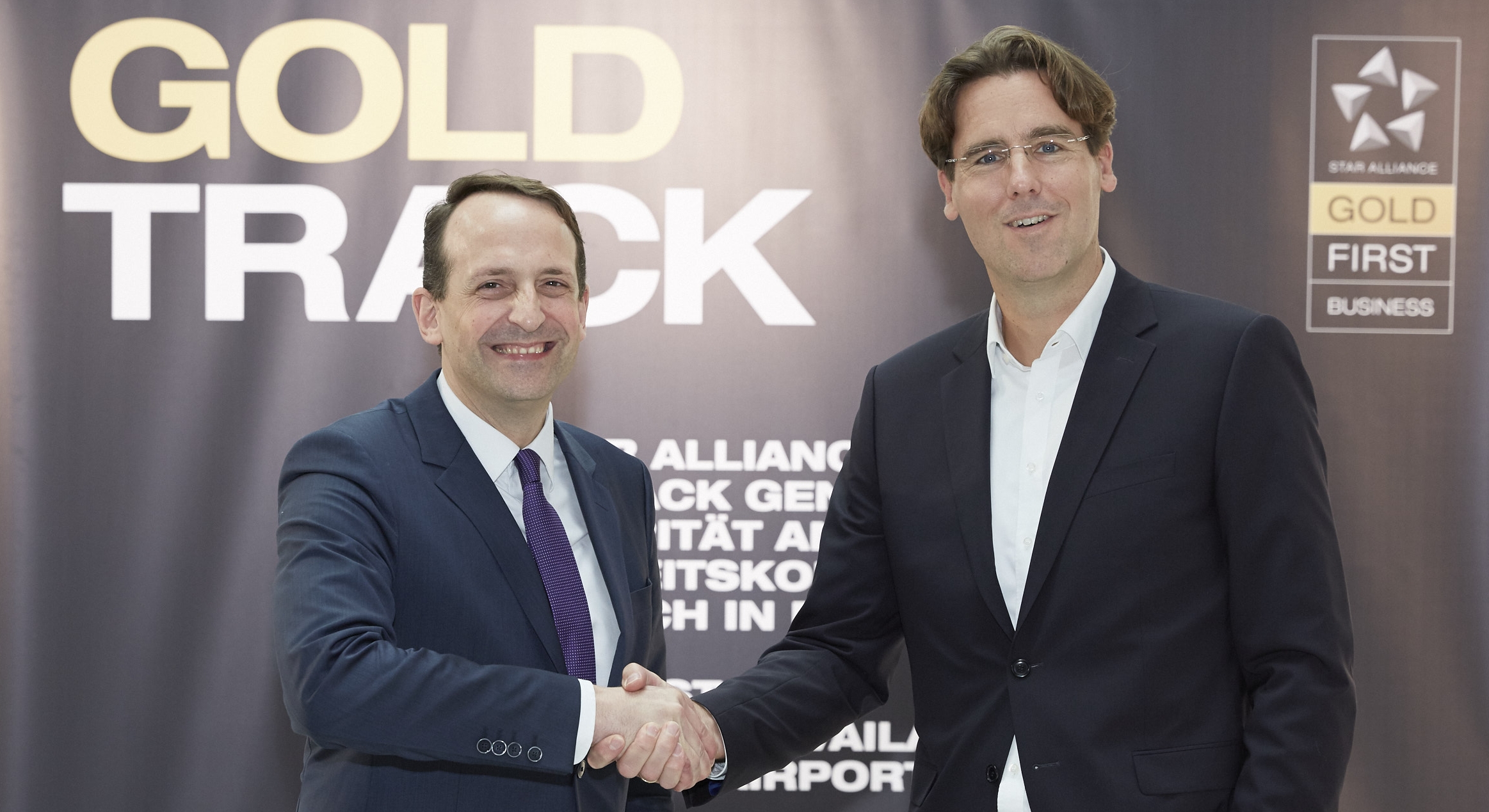 Senior Executive Vice President at Fraport AG for Airside & Terminal Management, Corporate Safety & Security Pierre Dominique Prümm (left) shakes hands with Lufthansa's Björn Becker, Senior Director Product Management Ground & Digital Services after Star Alliance Gold Track branding is installed in Frankfurt airport