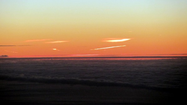 High-altitude clouds already in the sunshine, before sunrise